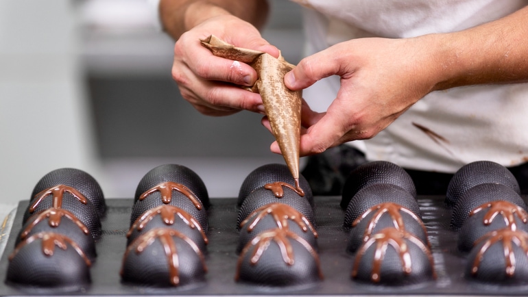 Professional confectioner decorating chocolates