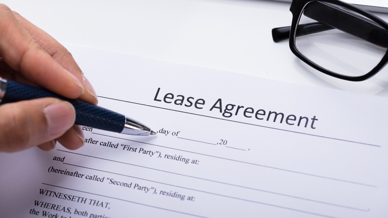 Person filling out a lease agreement